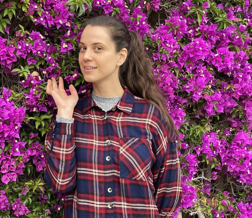 student in front of beautiful pink flowers.