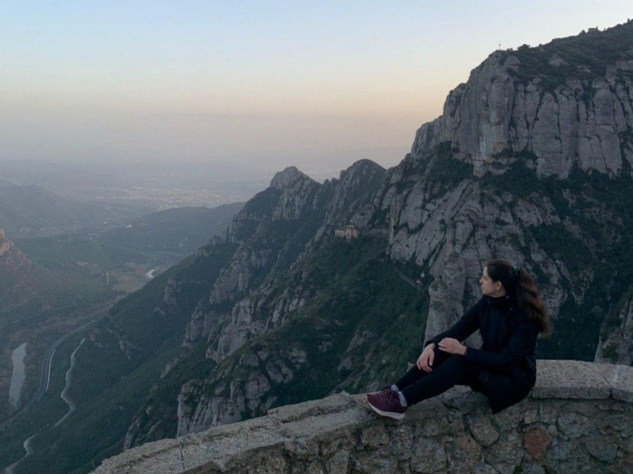 Girl sitting and taking in views of Montserrat mountain.