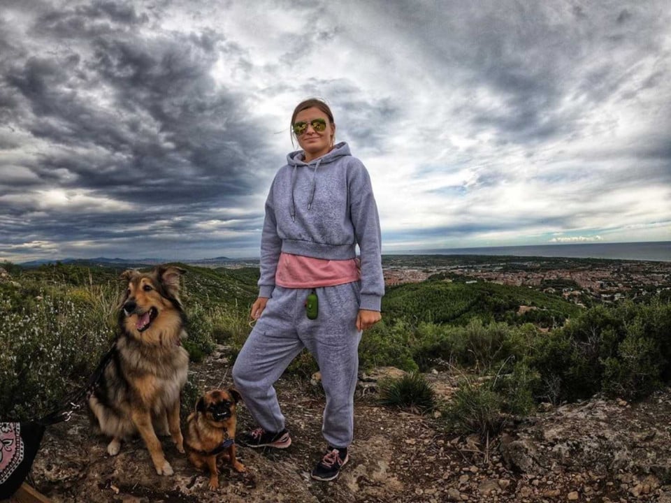 student in the hills with her two dogs.